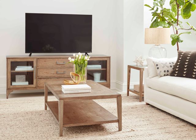 light beige living room with a light wood table and media console, stylized, with a tv on the console and a beige couch on the right