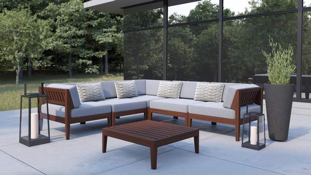Front view of an l-shaped modular wooden contemporary outdoor sofa on a concrete patio with outdoor accents in front of a large window
