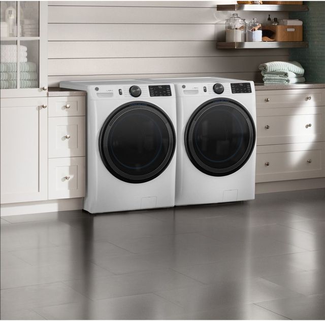 front angled view of a white ge washer and dryer in a white laundry room 