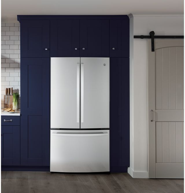 Stainless steel GE French door refrigerator installed against a blue accent wall