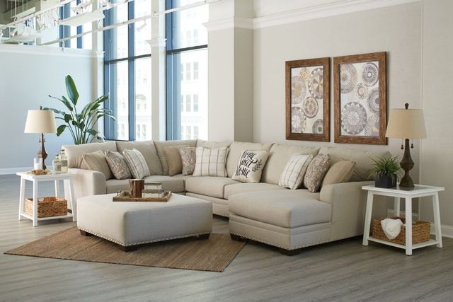 front view of a white sofa in a modern staging area with windows in the background