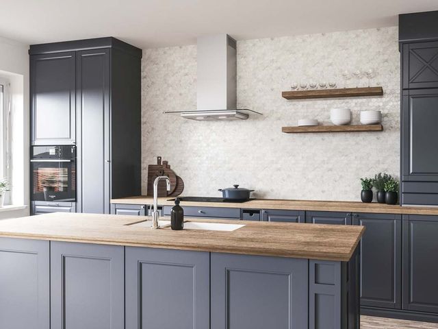 view of a modern kitchen with white walls, light wood countertops, and black cabinets. Centered above the range is a stainless steel and glass wall mount range hood.