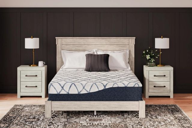 front view of a modern brown and beige bedroom with a mattress on a light wood bed, and accent pillows on top of it