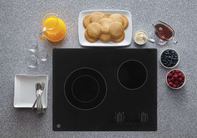 ge electric cooktop with breakfast around it, including orange juice, pancakes, and syrup