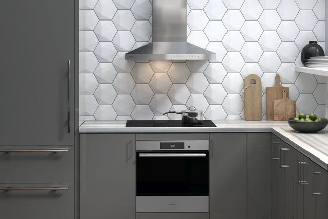 front view of an induction cooktop and ventilation in a modern white kitchen