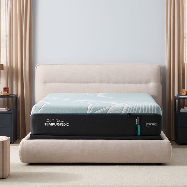 front view of a modern bedroom with light blue walls, beige curtains, and a tempur pedic mattress on a white bed frame