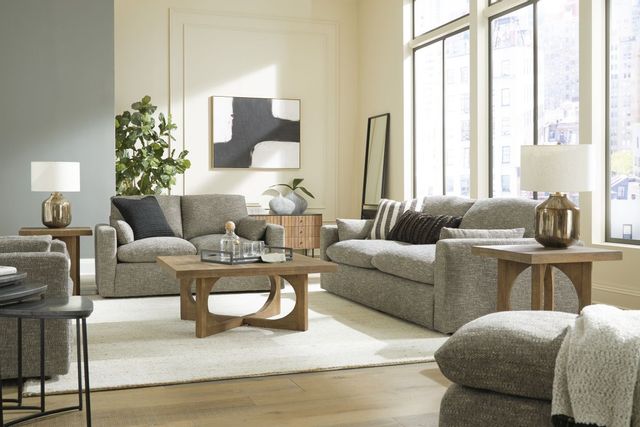 front view of a modern living room with light sage green sofas and walls and light wood accents