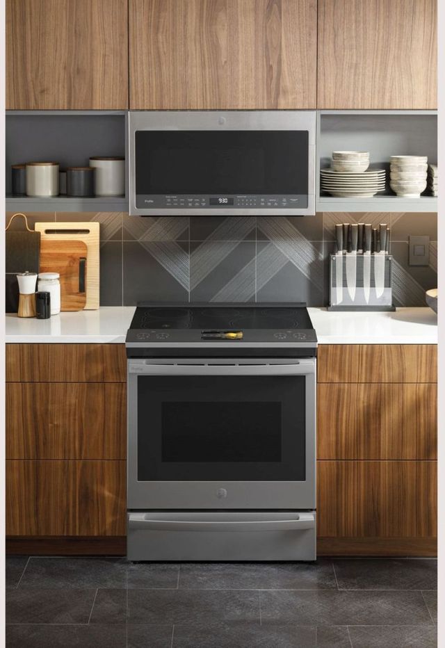 Slide in GE electric range in a kitchen with wood cabinets