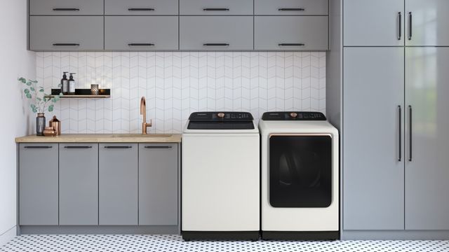 view of a white and grey theme laundry room with white samsung washer and dryer surrounded by cabinetry and countertop