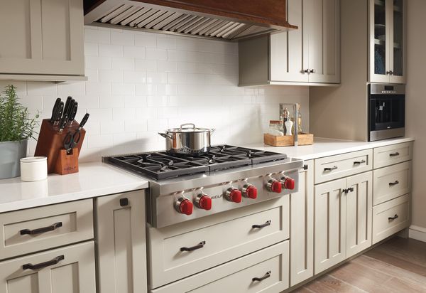 stylish kitchen featuring Wolf 36" Pro Natural Gas Style Natural Gas Rangetop with red knobs