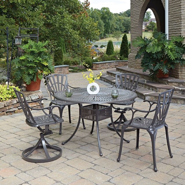 front view of a metal outdoor dining table on a traditional style outdoor patio