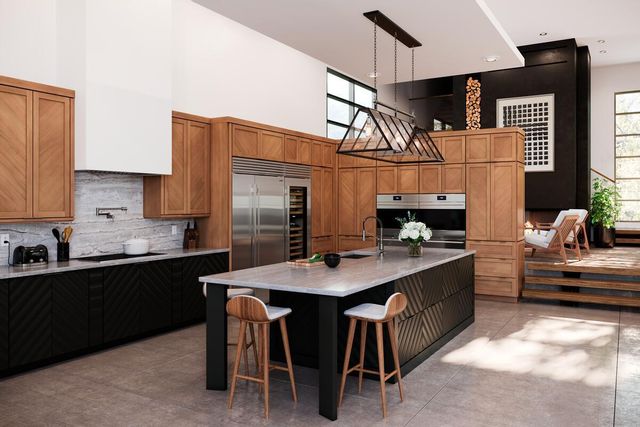 view of a modern kitchen with wooden cabinets, a marble island, and stainless steel appliances including a 48 inch refrigerator thoughtfully incorporated into the space