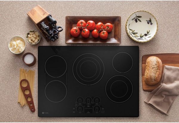 GE Profile 30" Stainless Steel/Black Built-In Electric Cooktop Surrounded by Ingredients 
