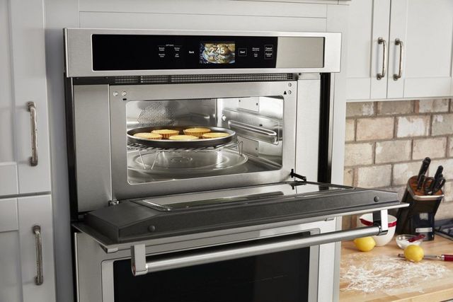 KitchenAid oven microwave combo with a microwave door open and food being cooked inside
