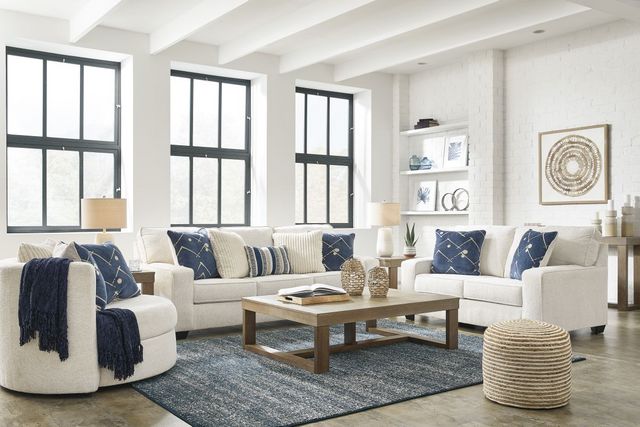 front view of a modern cozy living room with a white sectional, sofa, and oversized swivel accent chair