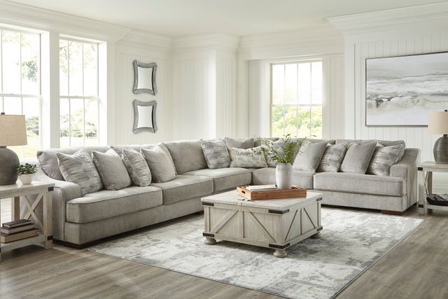 front view of a large l-shaped beige sectional in amodern farmhouse living room with a white wood coffee table and matching end tables on each side