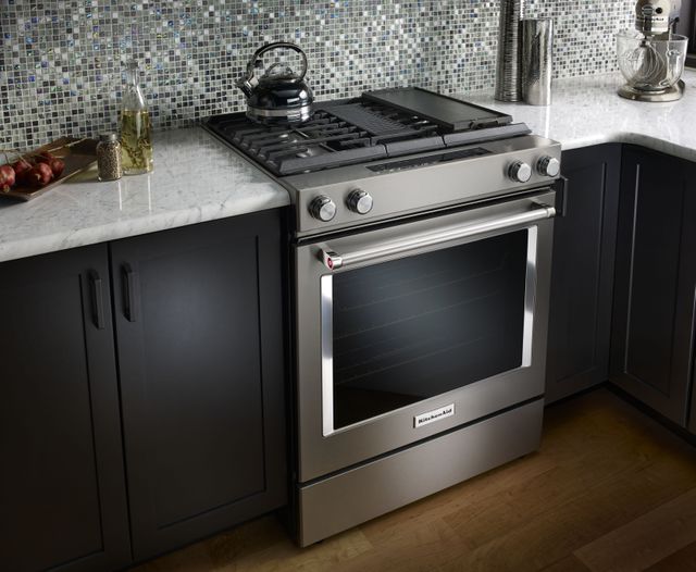 KitchenAid dual fuel range in a kitchen with a tile blacksplash
