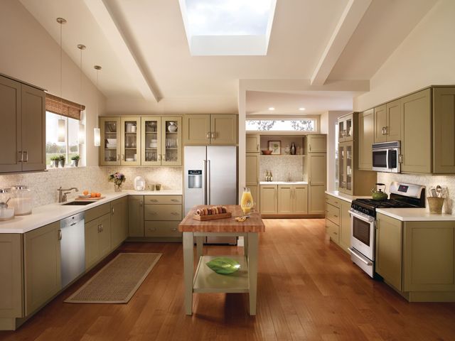 modern beige kitchen with olive green cabinets and a kitchen appliance package