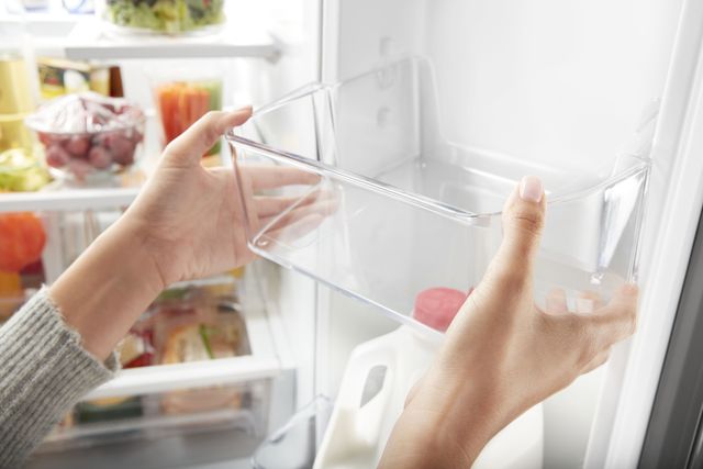 close view of somebody readjusting the shelf inside their french door refrigerator