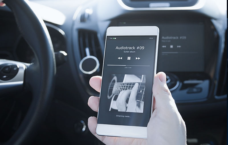 person connecting their phone to their car audio system