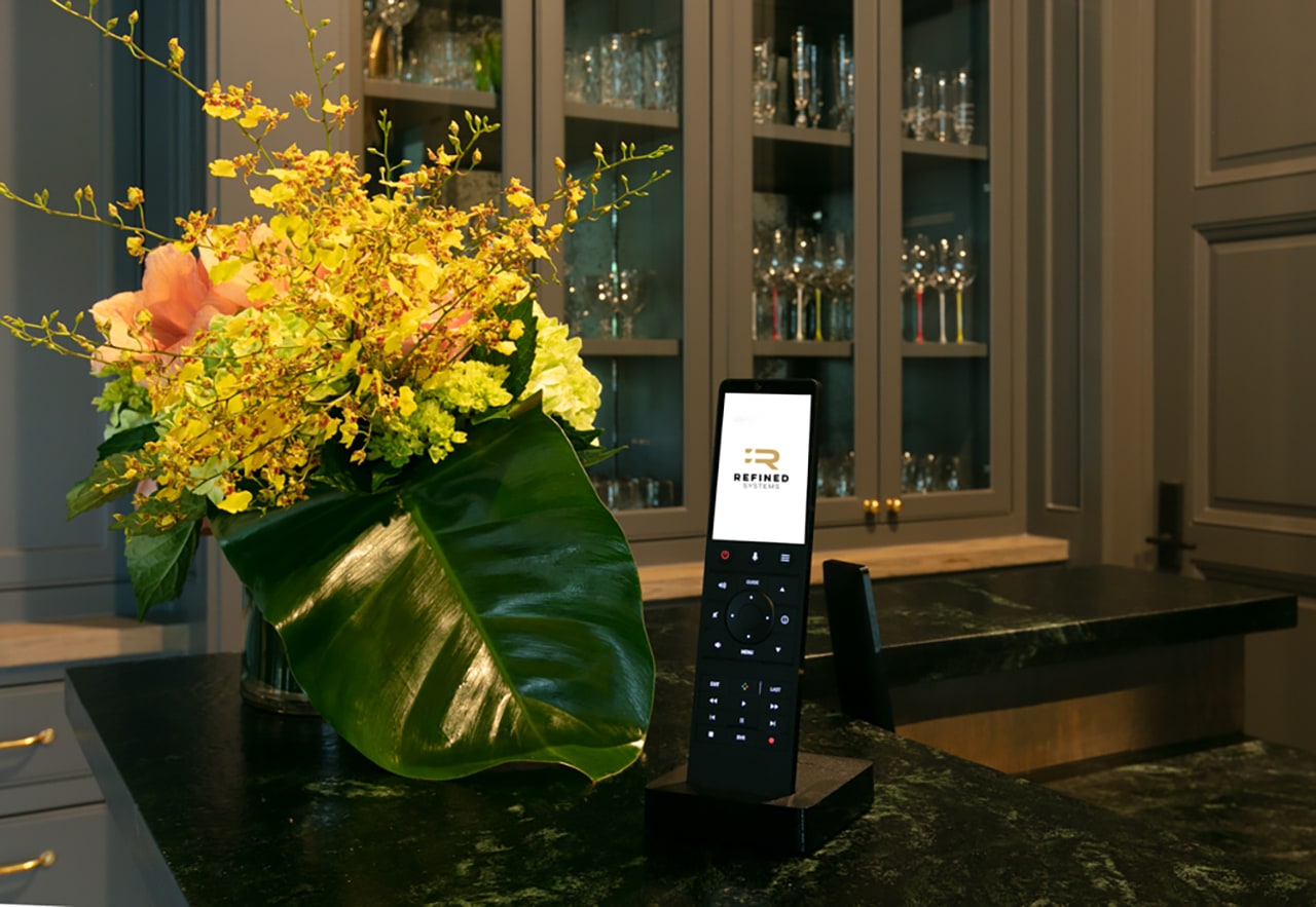 Smart home control on a counter next to fresh flowers