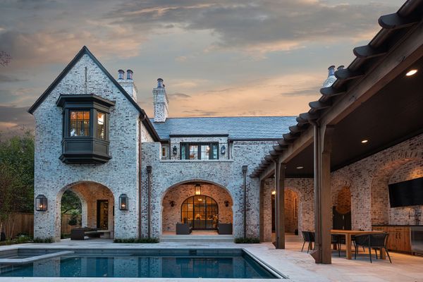 The outside of a brick home in Texas, with an expertly installed outdoor lighting scheme