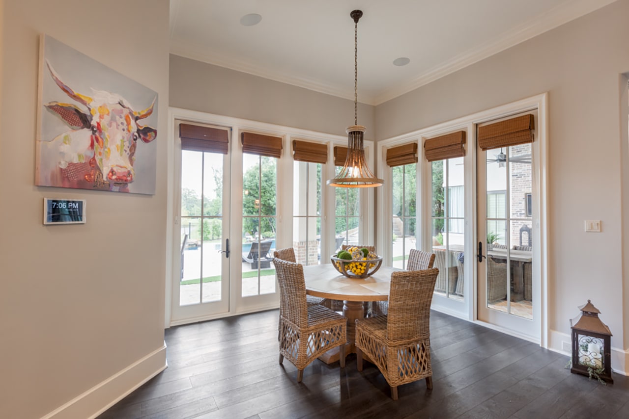 Smart control beneath a cow painting in the breakfast area of a Texas home