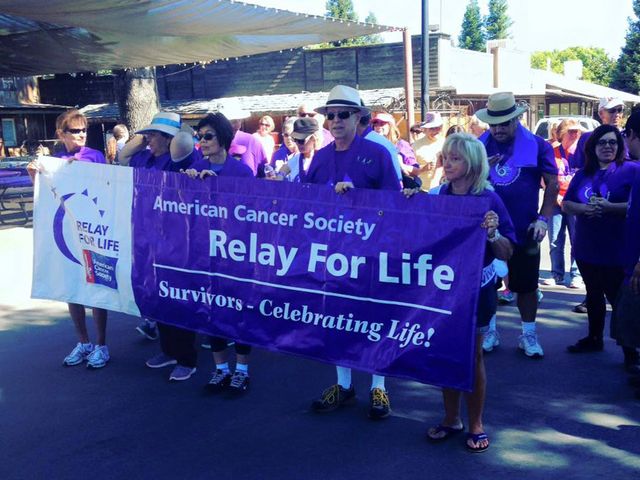 Picture of Idler's team members holding an American Cancer Society Relay for Life Banner